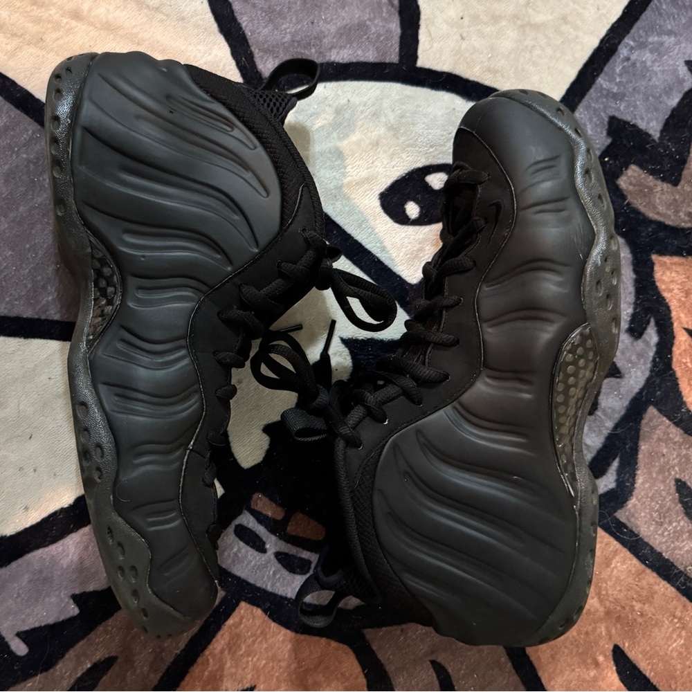 Black Nike Air Foamposite One trainers.